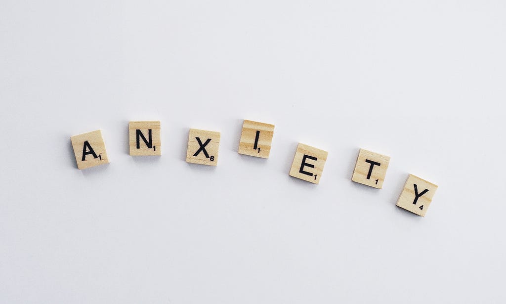 Scrabble play pieces spelling out the word “Anxiety”.