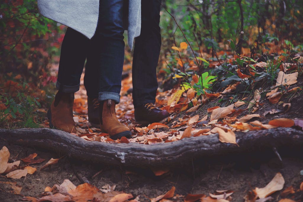 two pairs of boots, walking together in the forest