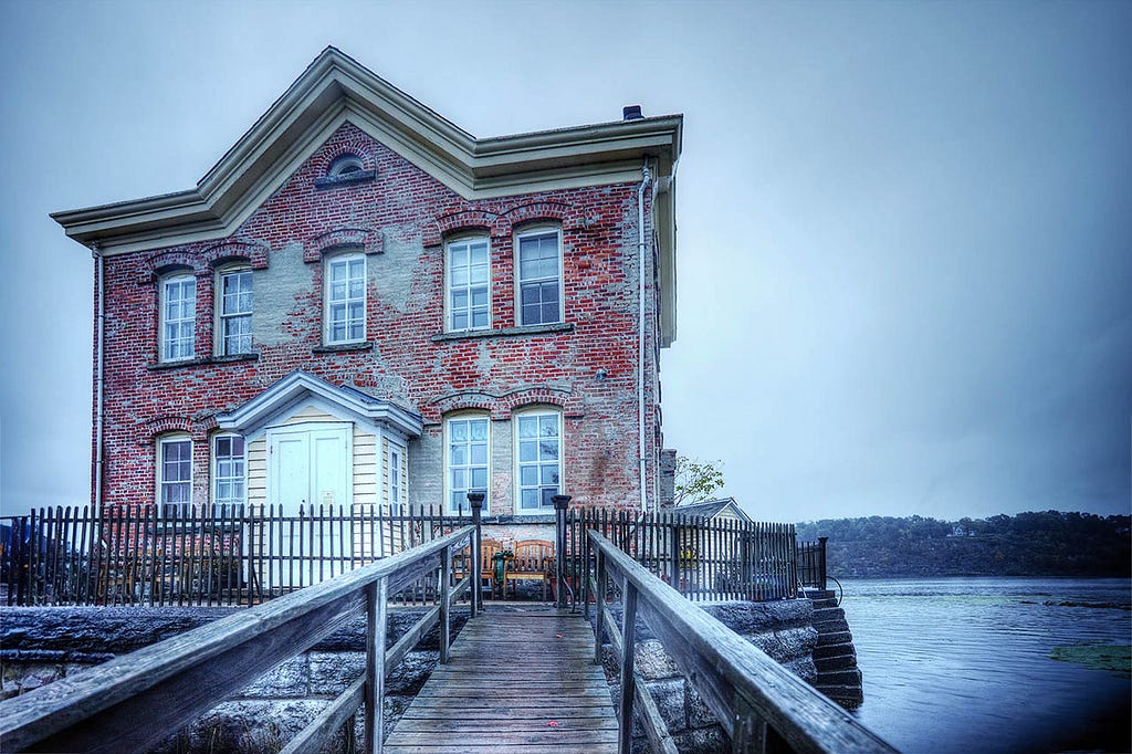 a red brick two story building on a river