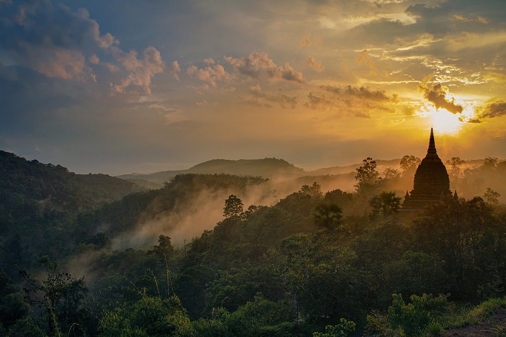 sunset pic of mountains and maybe buddhist temple