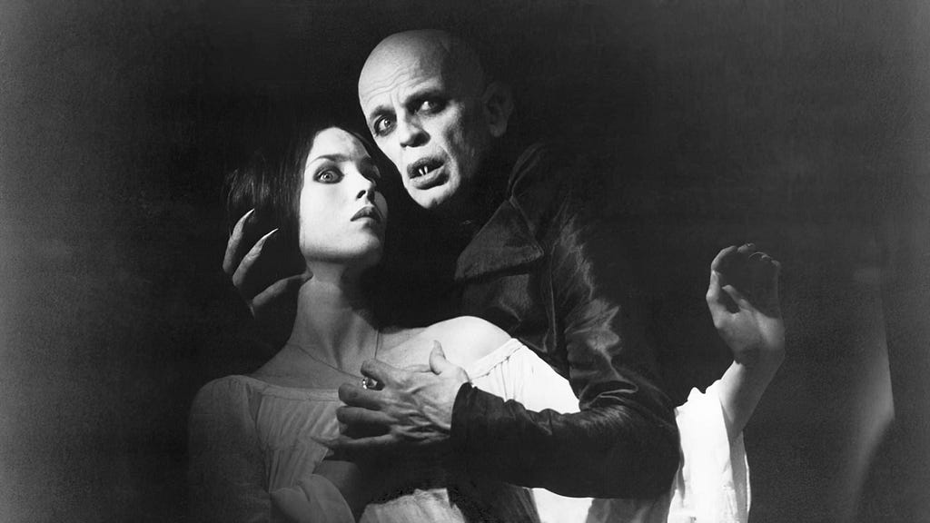 A promotional still from Nosferatu (1979) in black-and-white, showing the main character Lucy (Isabelle Adjani) and Count Dracula (Klaus Kinski).