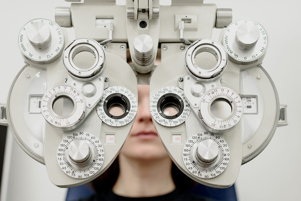 Woman having eye exam with an ophthalmoscope