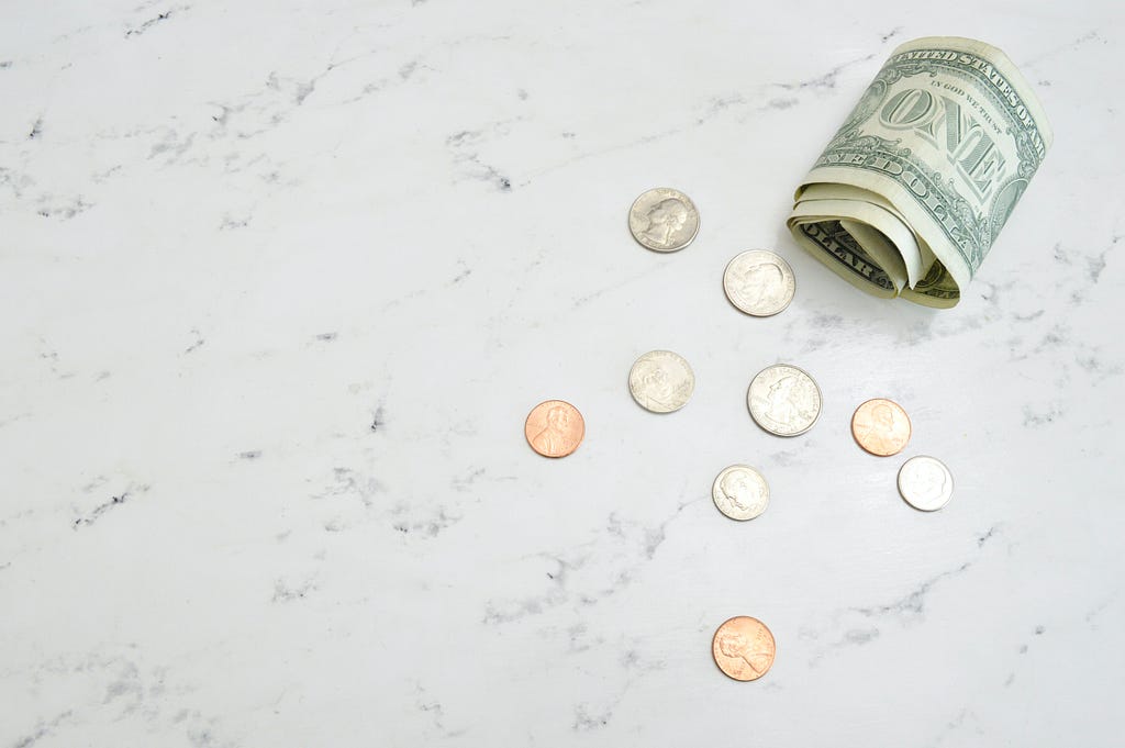 A photo of very little money on a marble surface because of the recession.
