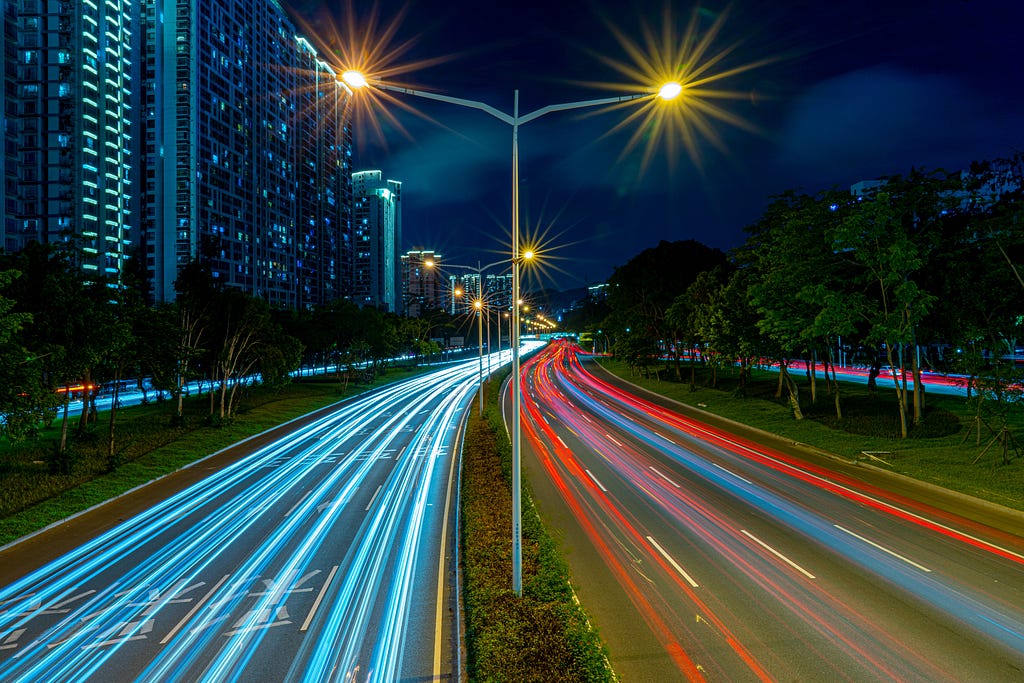A road with fast moving lights on it by Abhay Gautam