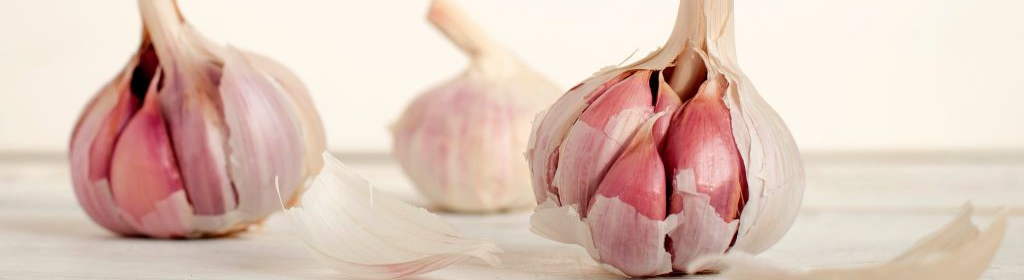 Three bulbs of garlic on a table.