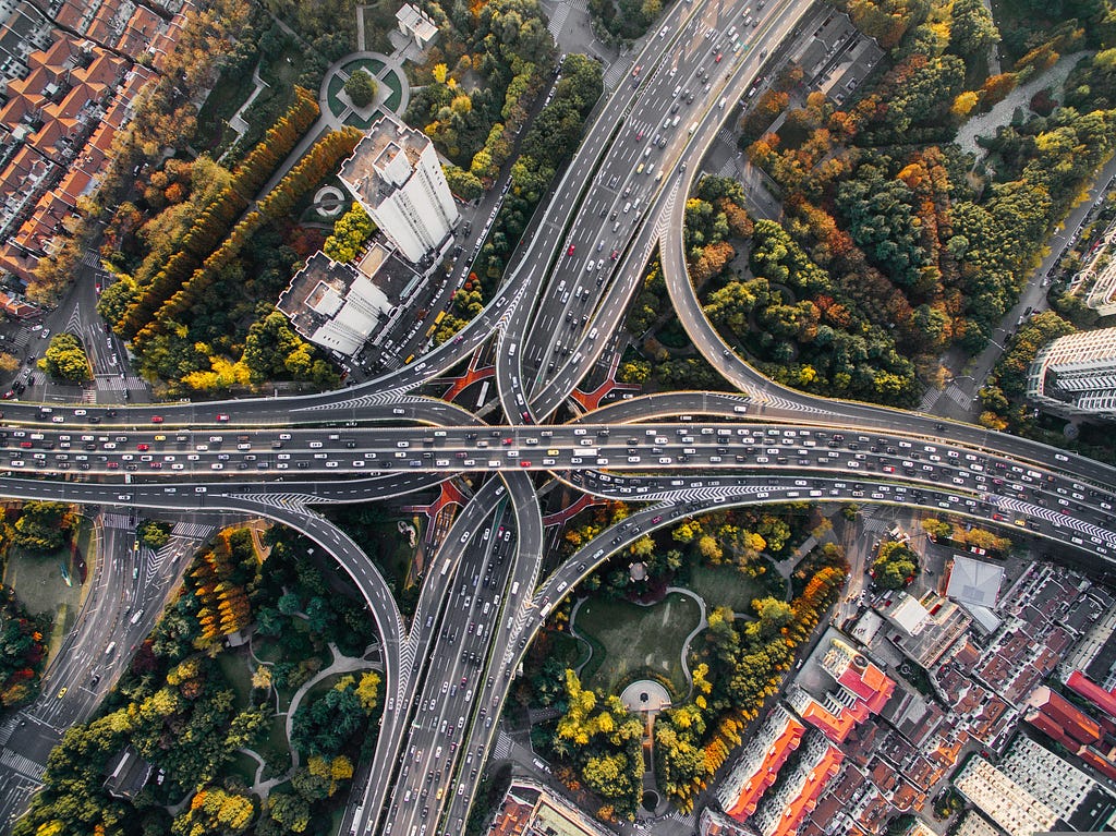 Aerial photo of a freeway junction surrounded by trees and vegetation