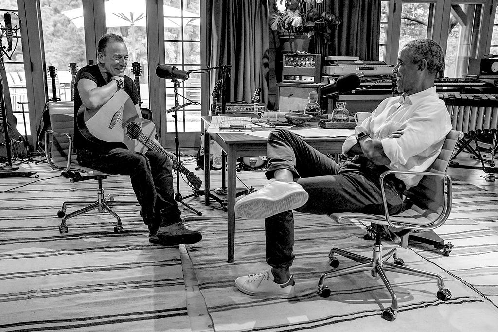 A black and white image of Bruce Springsteen and Barack Obama recording their podcast.