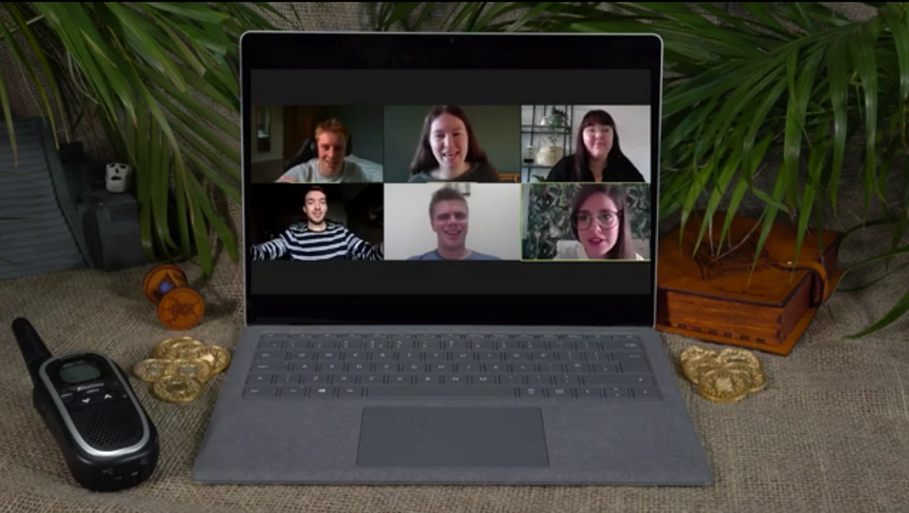 Six participants are shown on a laptop screen surrounded by props as they take part in a remote immersive learning experience