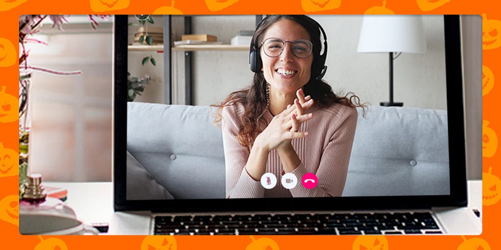 A video call with a therapist can save lives. She is sitting on a couch, smiling and clasping her hands.