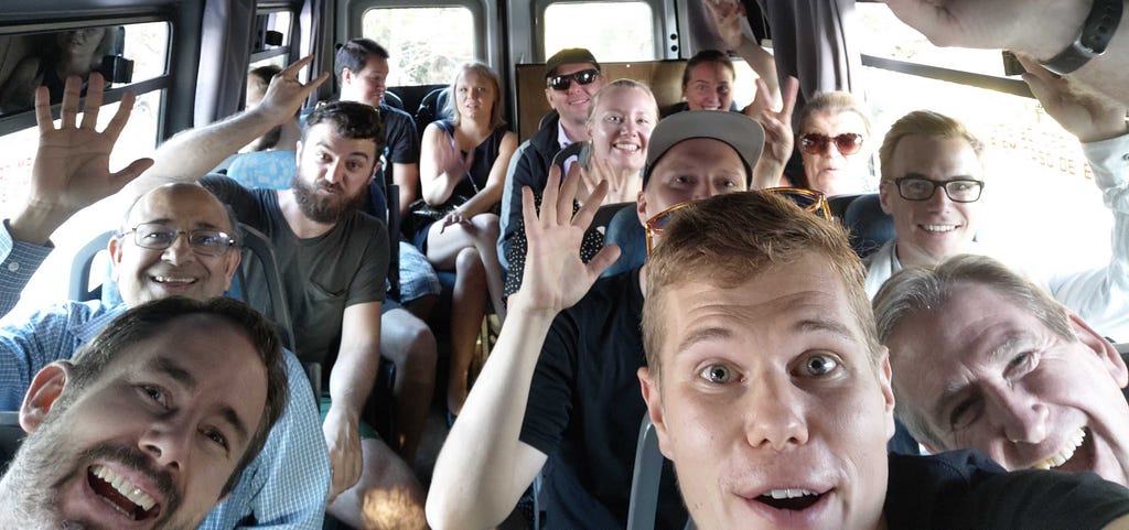 The Verifa team waving while sat in a minibus