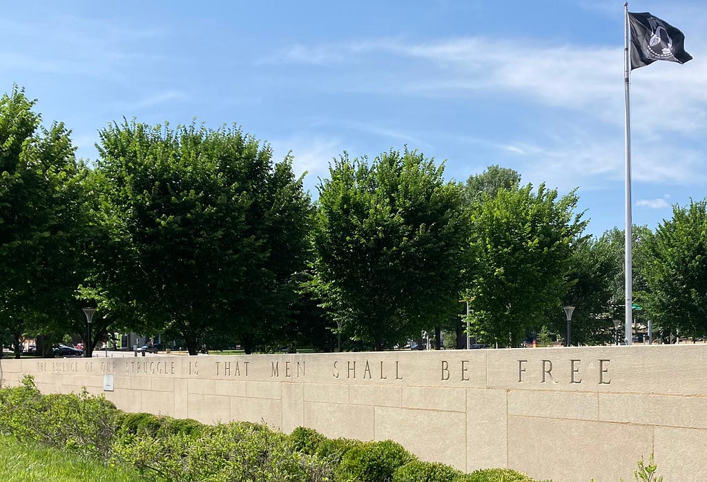 Low wall by St. Louis Soldiers Memorial enscribed “The Essence of Our Struggle Is That Men Shall Be Free — Franklin Delano Roosevelt.”