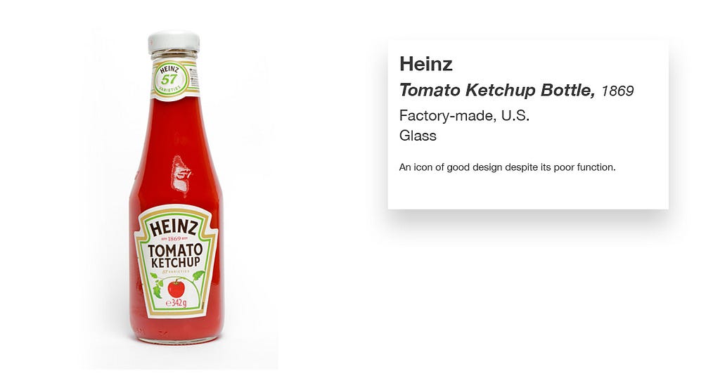 A Heinz ketchup bottle with what looks like a museum label with the following text: Heinz; Tomato Ketchup Bottle, 1869; Factory-made, U.S.; Glass; An icon of good design despite its poor function
