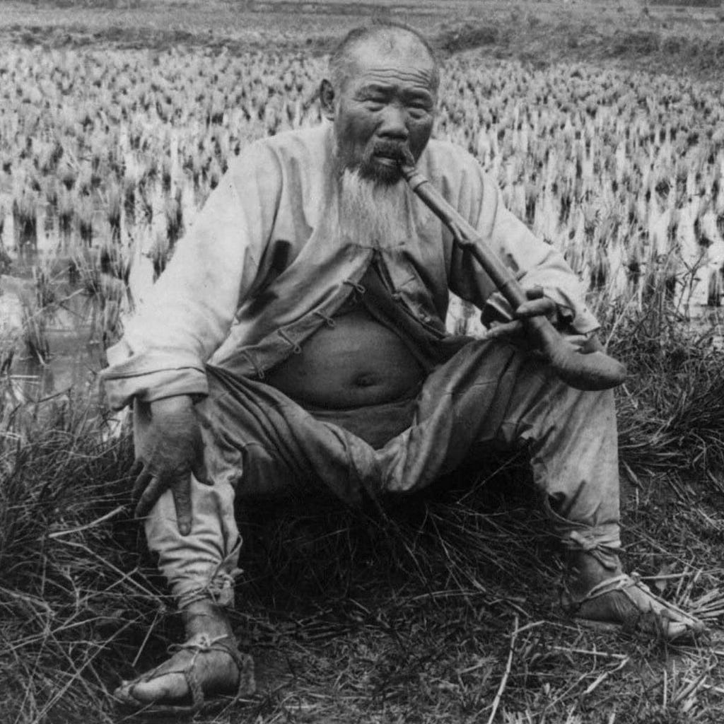 Wise Chinese farmer relaxing in the valley after a hard day’s work