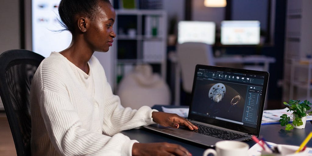 A female product deisnger designing a product on her laptop.