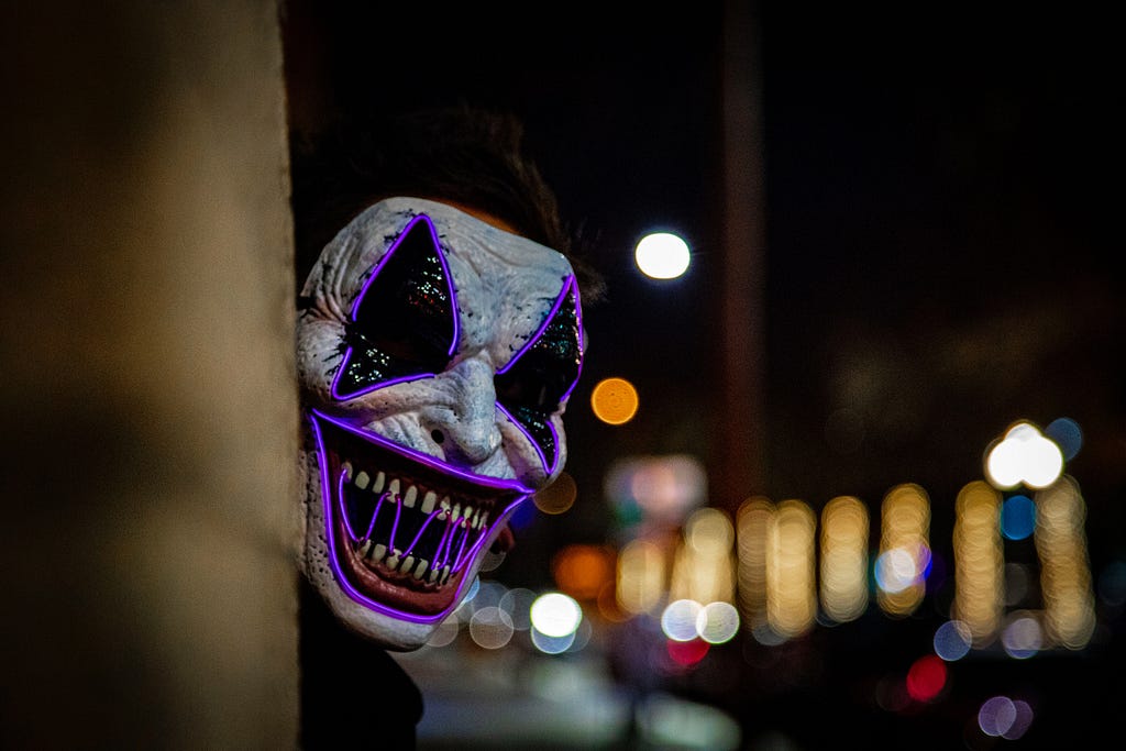 A person in a mask peeking around a corner