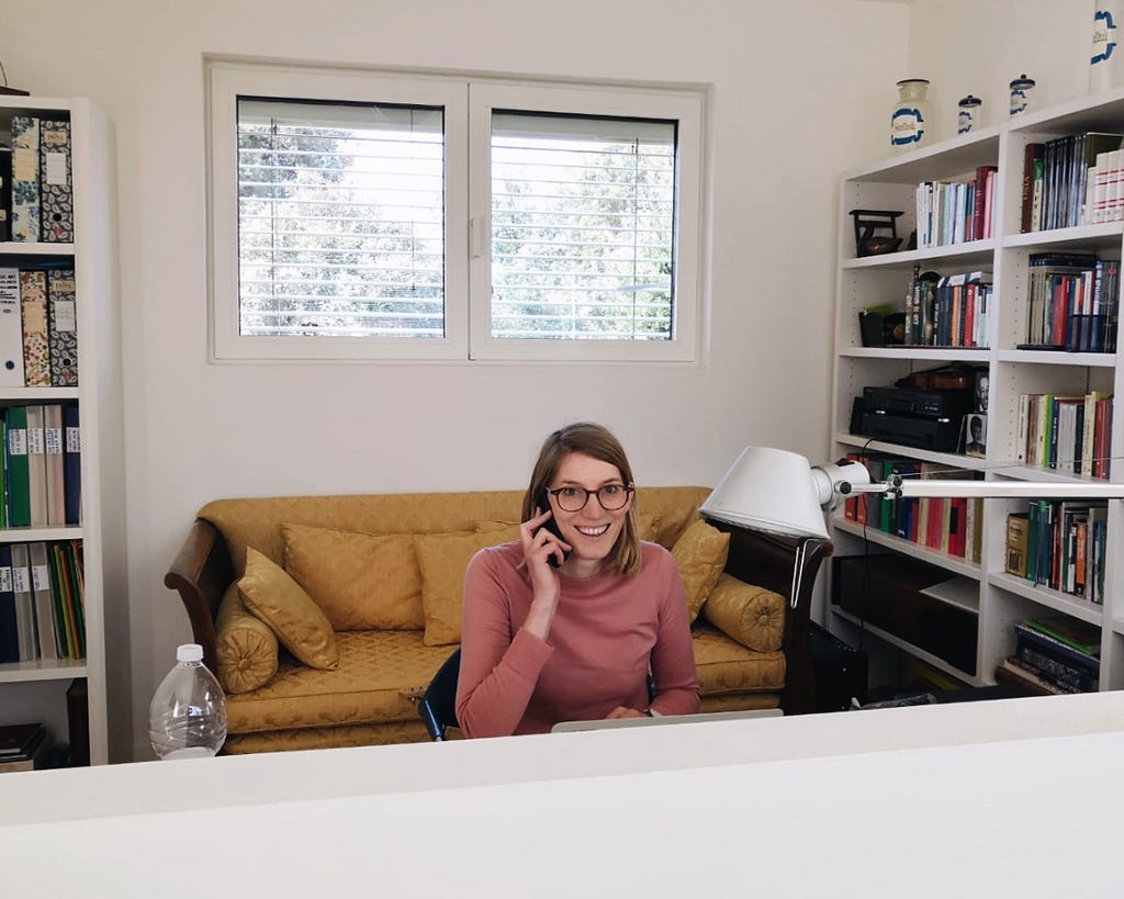 The author on the phone at a desk smiling