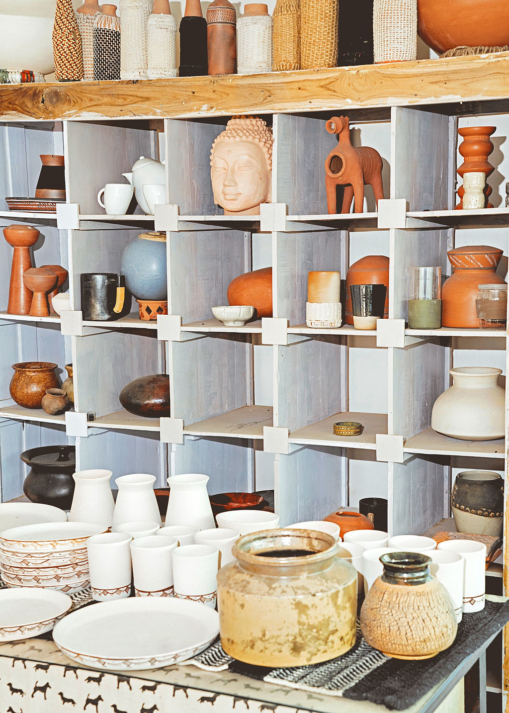 Shelves full of pottery and sculptures inside the studio at Bhuj.