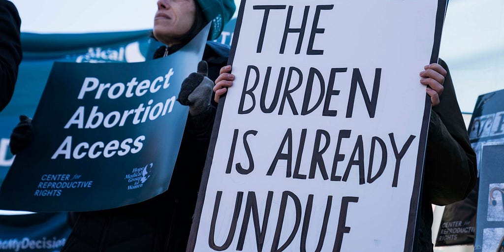 Demonstrators hold banners in an abortion rights rally outside of the Supreme Court on March 4, 2020.