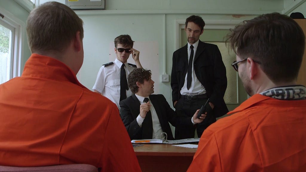 During  an immersive theatrical event as the prison warden interrogates a pair of learners dressed in orange prison jumpsuits