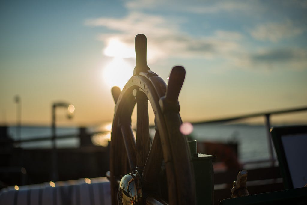 Sun set image of a boats steering wheel