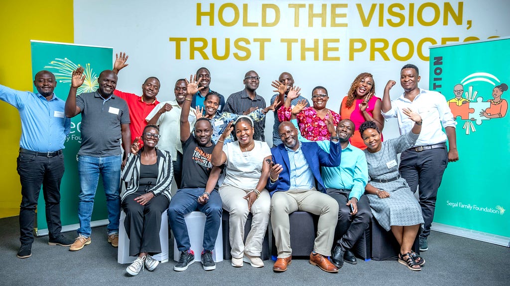 A group of Ugandan adults pose happily for the camera