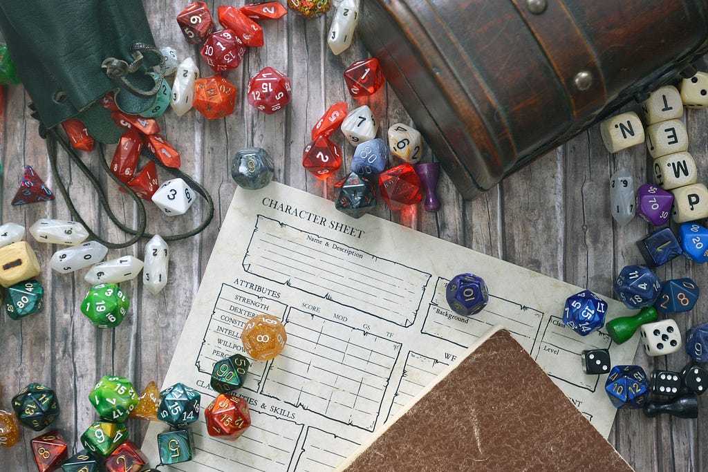 a variety of dice spread out over a partially-covered character sheet