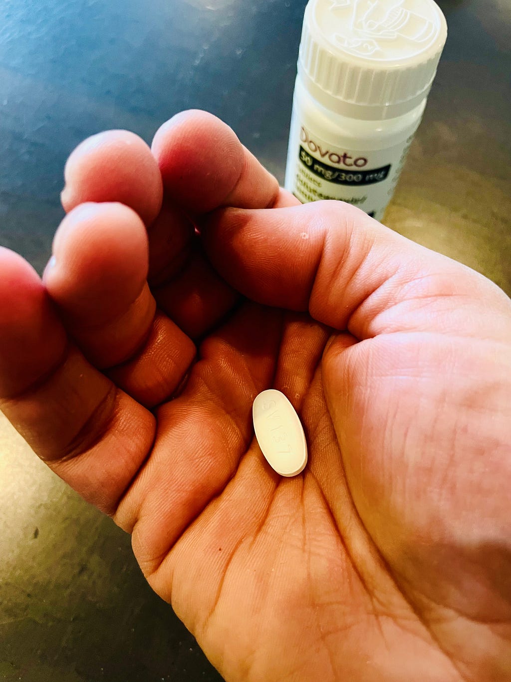 Ant Babajee holding a Dovato pill in his hand