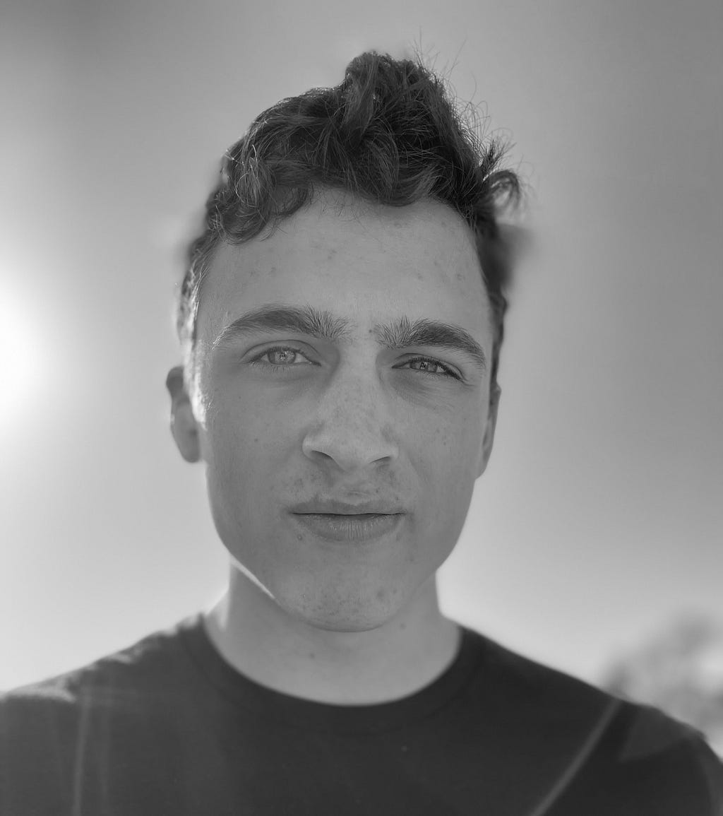 A teenage boy stares into the camera in a black and white photograph.