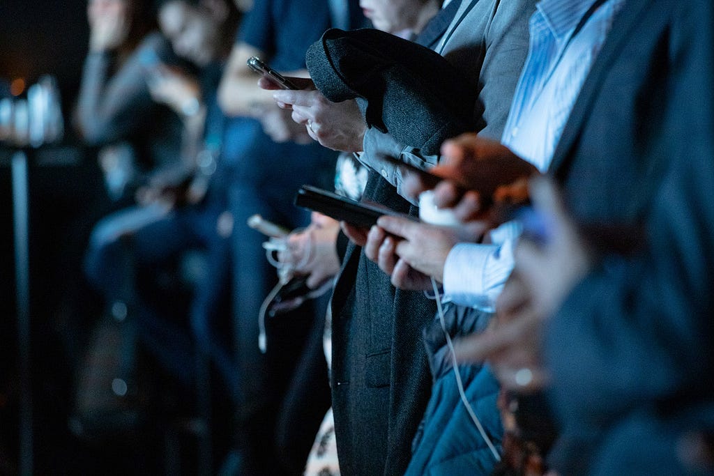 image of a row of people in suits looking at cell phones
