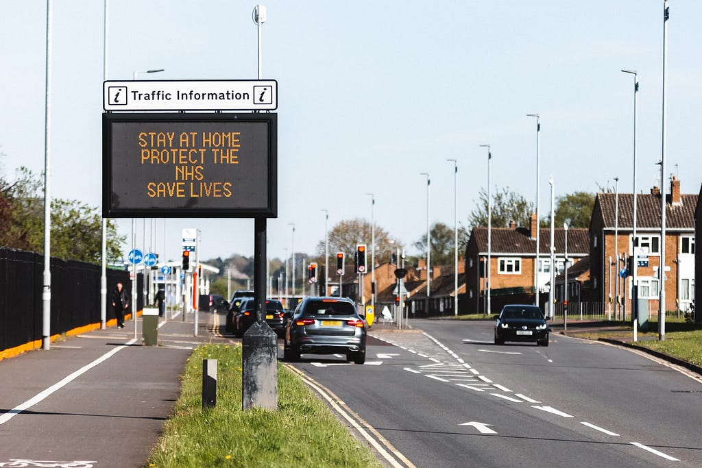 Sign on the motorway in the UK with Traffic Info: Stay at home. Protect the NHS, Save Lives. Advice from the government.