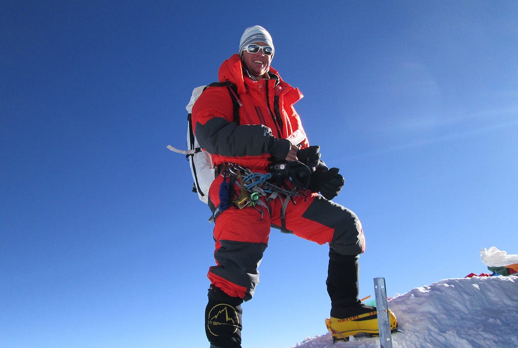 Walter Hailes stands atop Mount Everest.