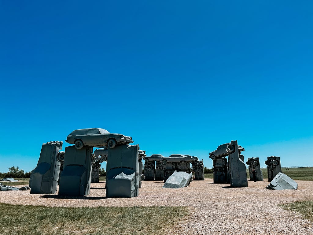 Old cars are pianted grey and set up to mimic Stonehenge