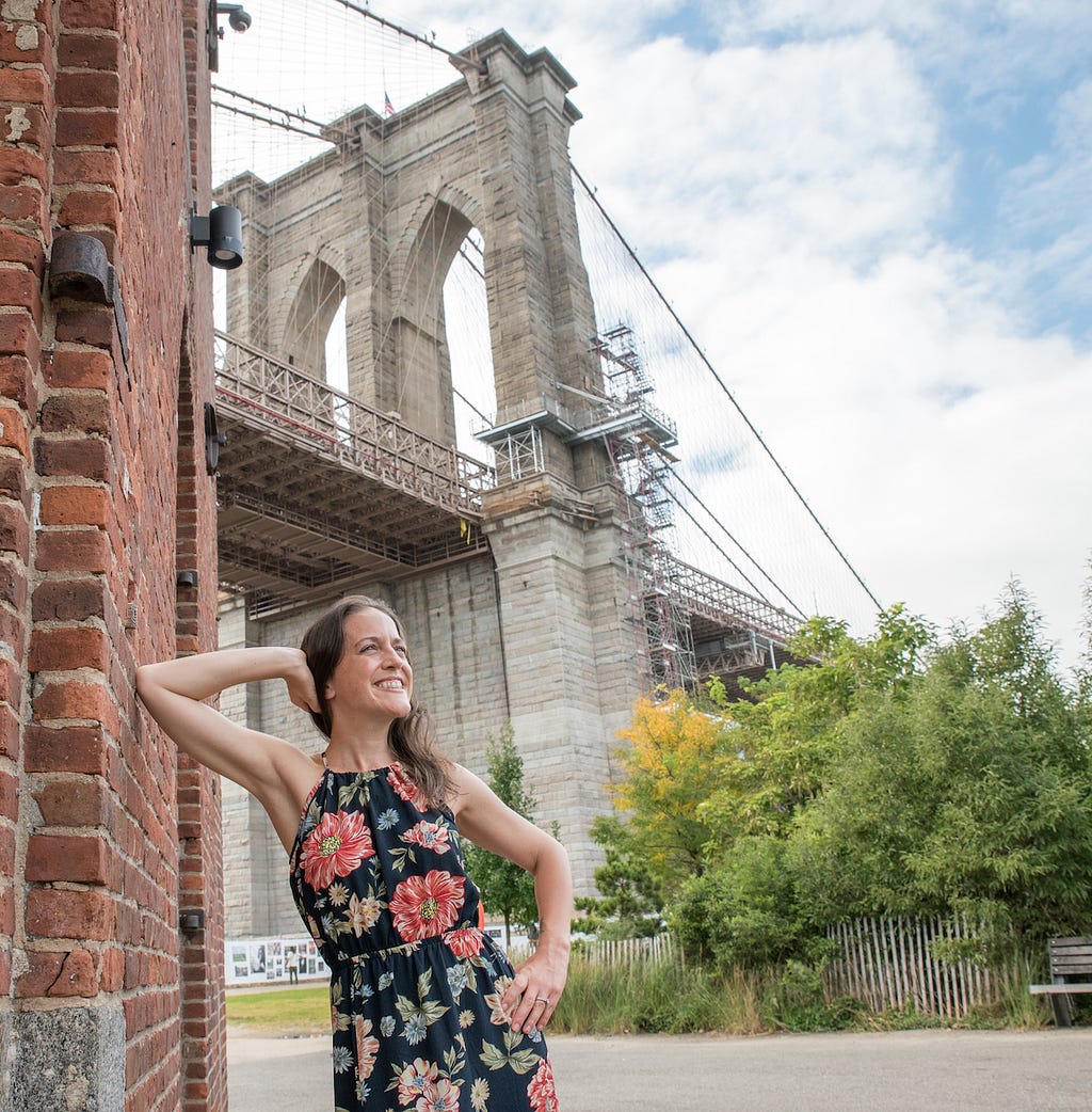 woman posing with the Brooklyn Bridge behind her