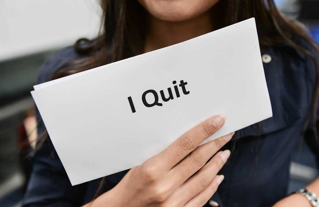 foto perempuan memegang kertas bertuliskan ‘I Quit’. Mengilustrasikan pegawai yang memutuskan resign. Salah satu tips pindah karier adalah membuat rencana matang sebelum resmi berhenti kerja.