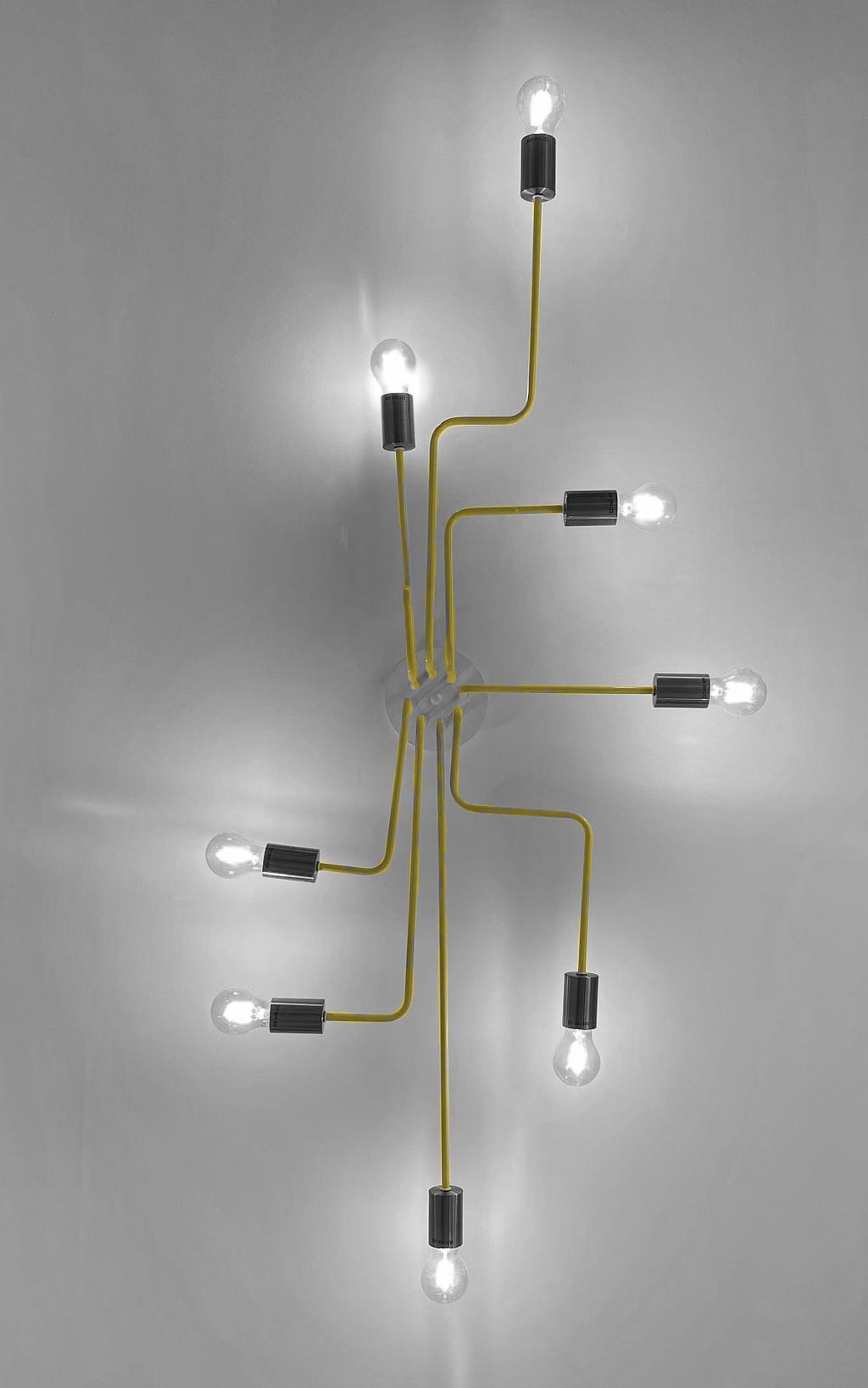 An image of a light fixture with multiple bulbs. All of the lights are connected with straight or bent lines to the plug.