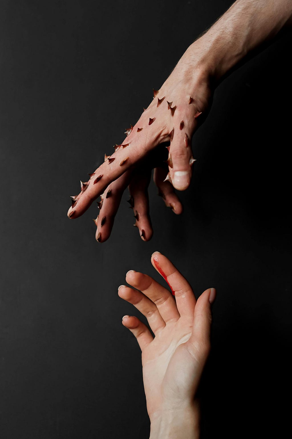 I concept art of a top hand with thorns directed towards a lower wounded hand that tries to reach out for the hands with thorn.