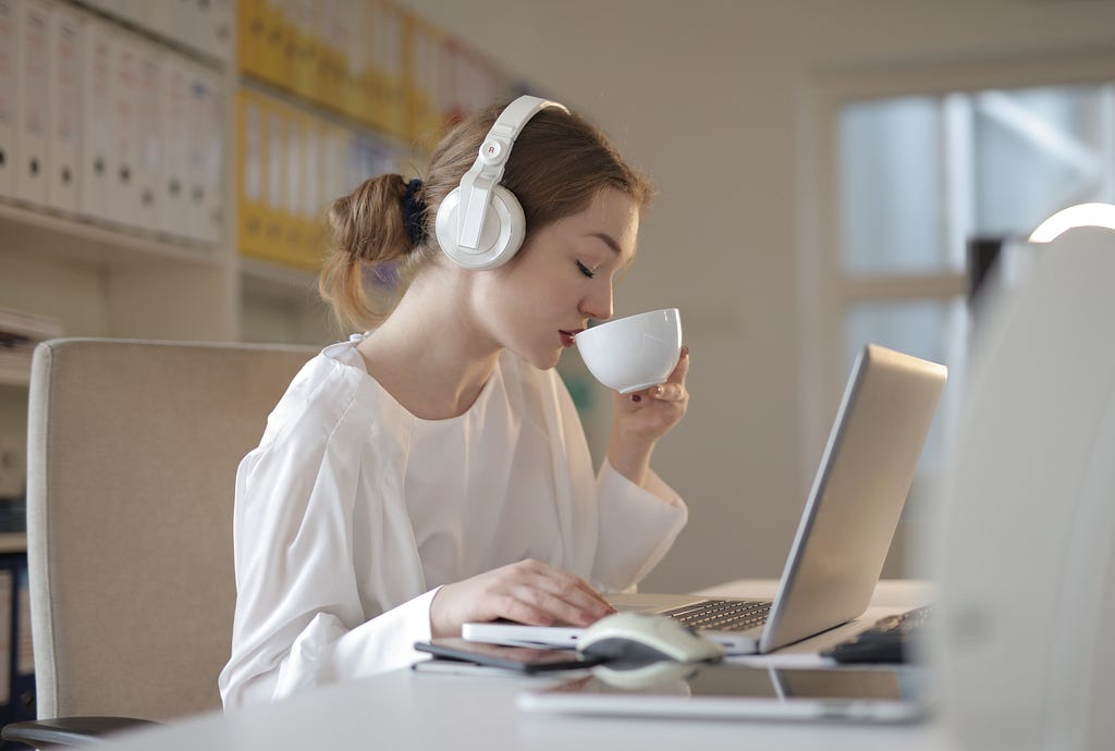 remote employee listening to music while working on her laptop