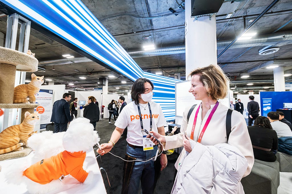 A woman tries something on her phone in the POSCO CES booth