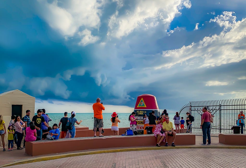 A crowd of tourists gathers at the southernmost point in the U.S.
