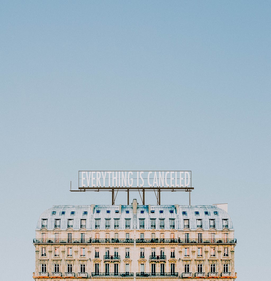 A building with a large sign in front of a blue sky. The sign says, “everything is cancelled.” Pandemic or society or BOTH?