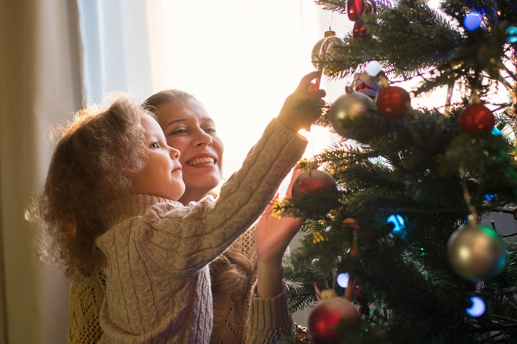 mother and daughter decorating the christmas tree
