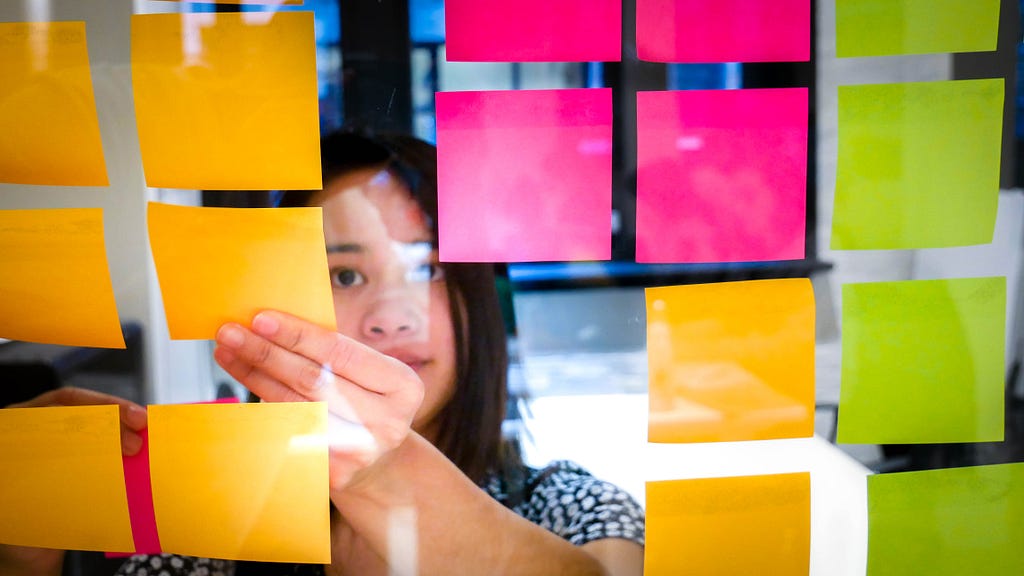 Picture of the author, Eikris, planning her next course using sticky notes.