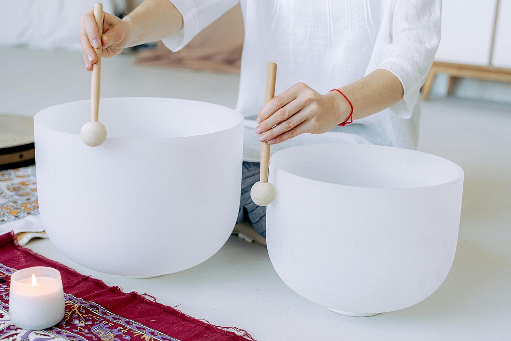 Person playing crystal singing bowls for sound therapy and healing