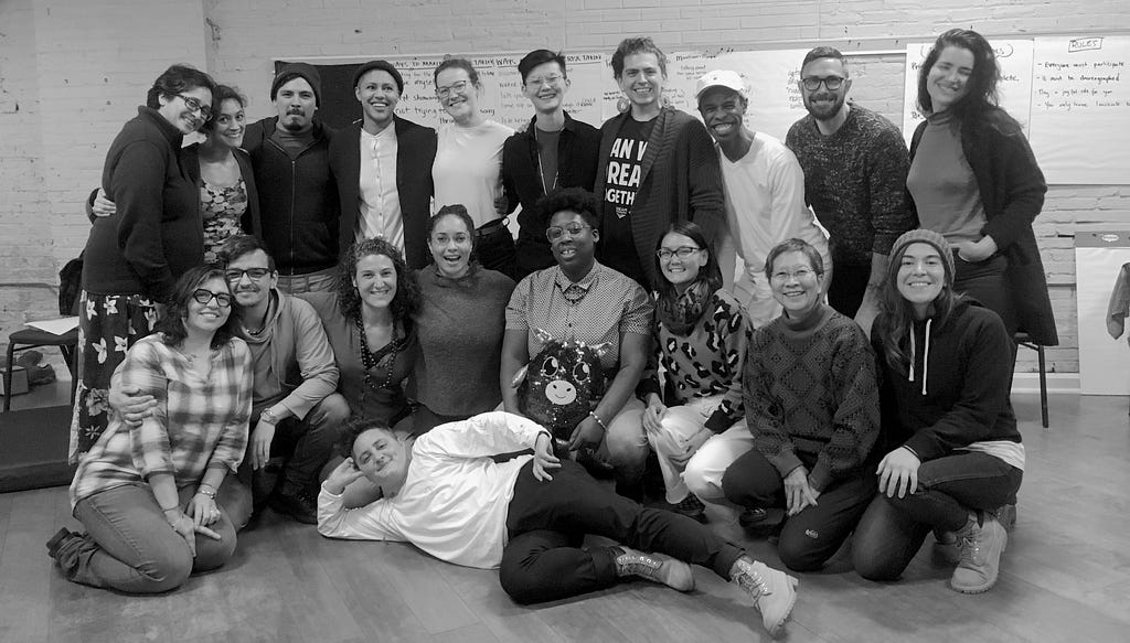 A group photo of 19 workshop participants in a training room