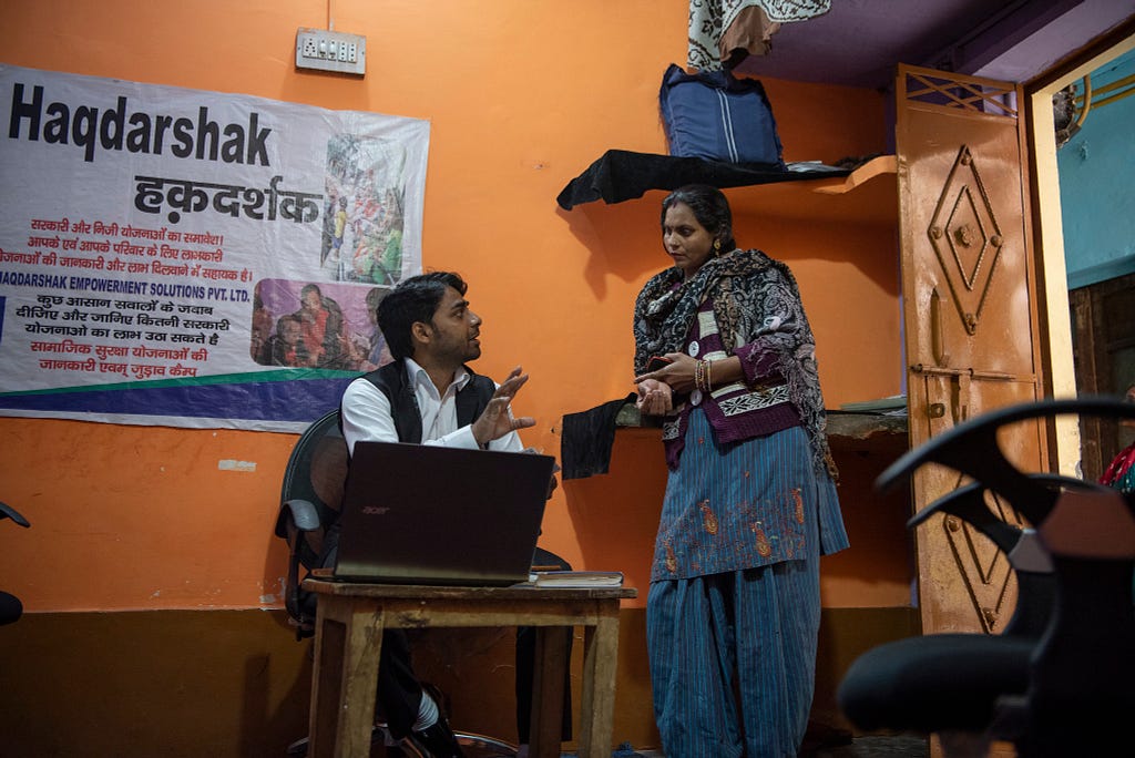 A Haqdarshak team member explains government welfare benefits to an Indian citizen