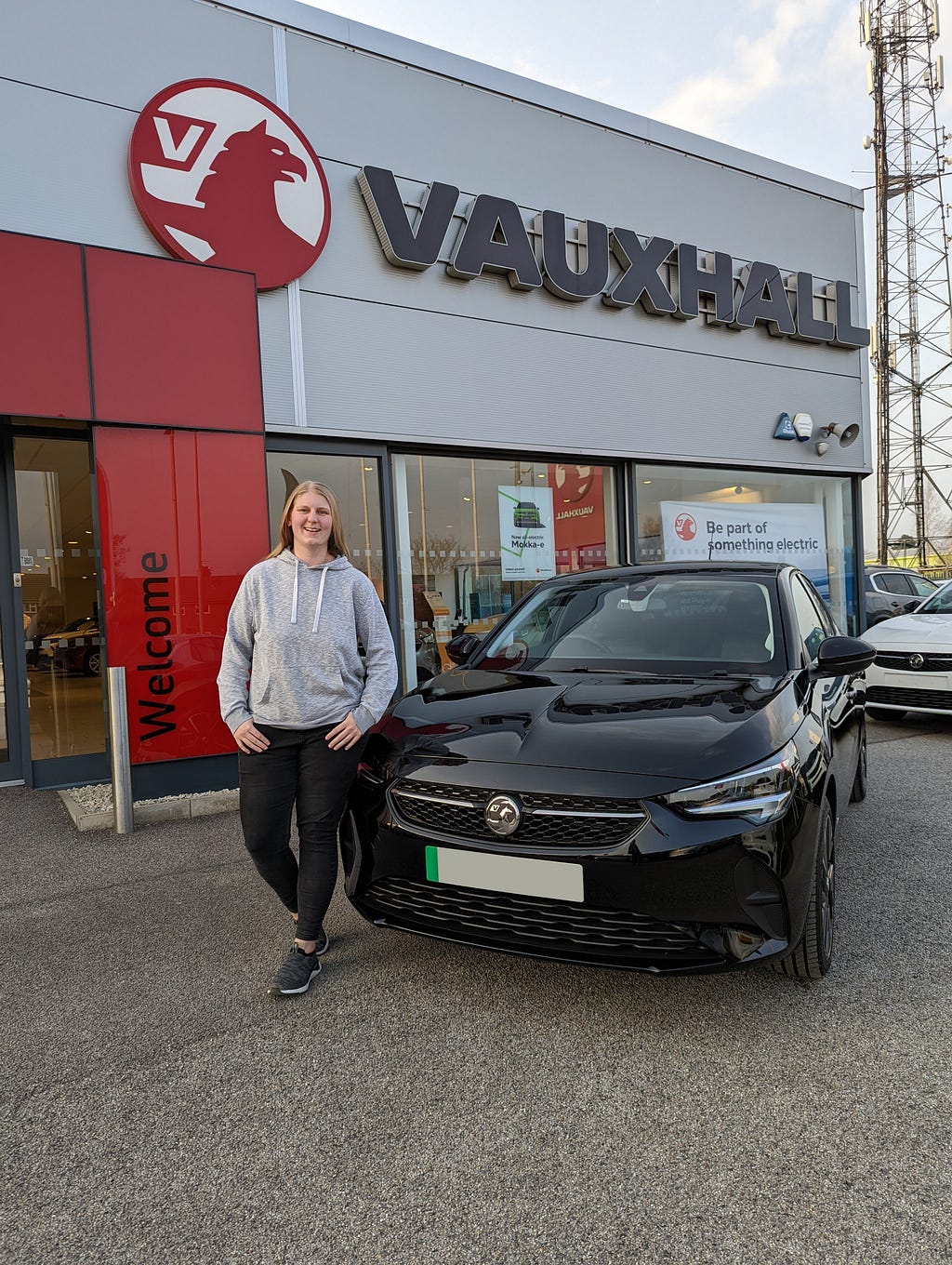 Sophie stood next to her Vauxhall Corsa-E outside the Vauxhall dealership.