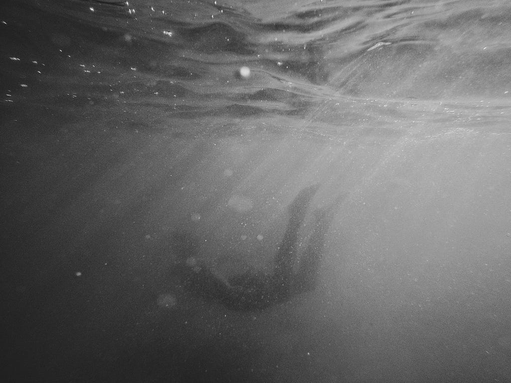 a murky image of a body floating under water