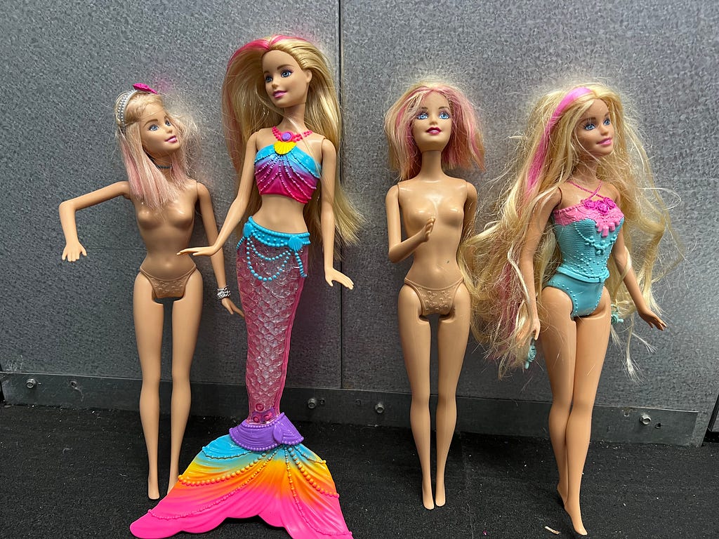 Four Barbie dolls