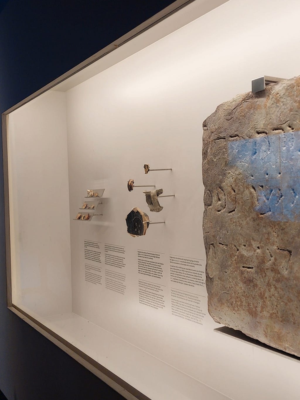 In this image, we can see part of a tombstone from the Jewish Cemetery of Montjuïc, and a few pieces of other archaeological remains.