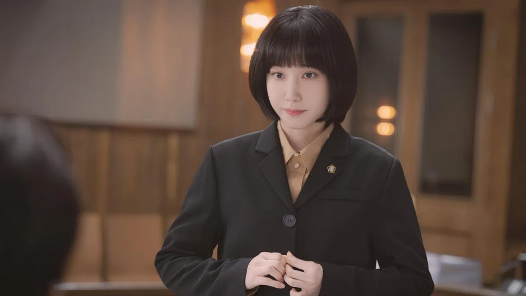 An image of Park Eun-Bin as the title character in “Extraordinary Attorney Woo.” She has an unflattering bob cut with a fringe.